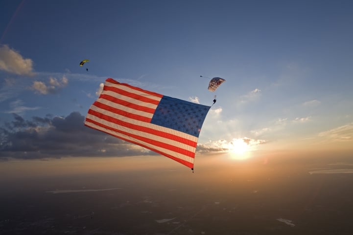 Skydiver performing with a large American flag